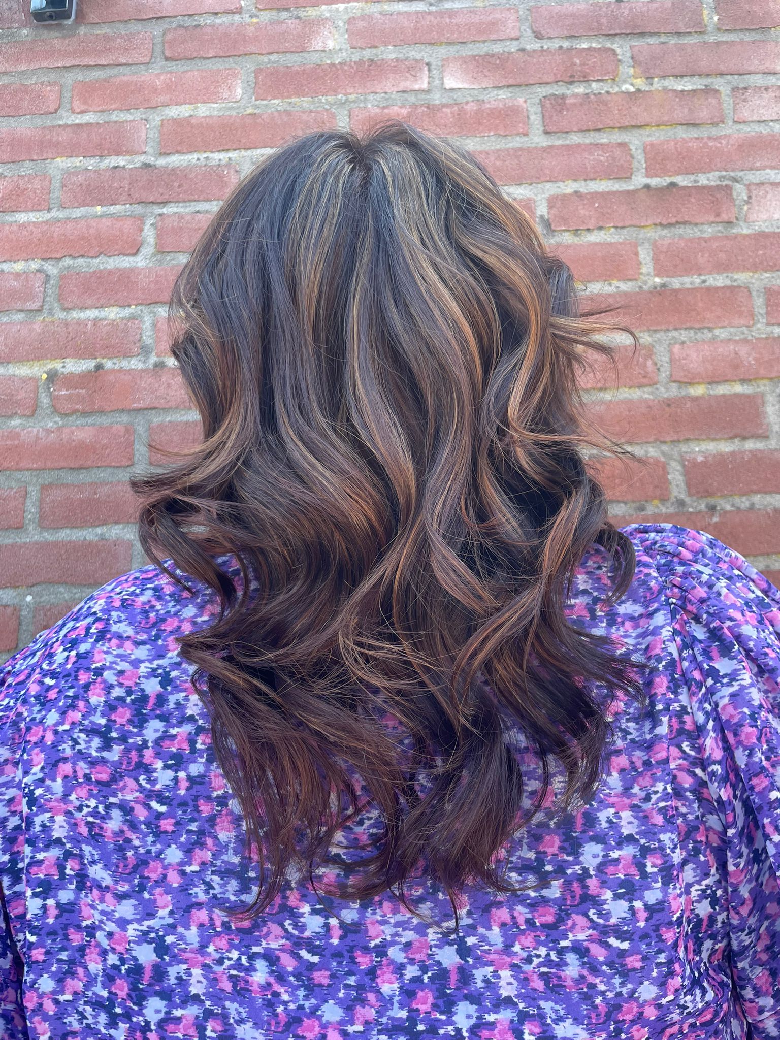Bruin haar met lichte kleurnuances en grote krullen